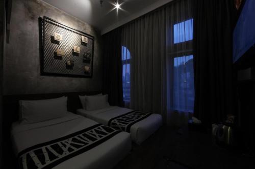 a room with two beds and a window at The Hulo Hotel & Gallery in Kuala Lumpur