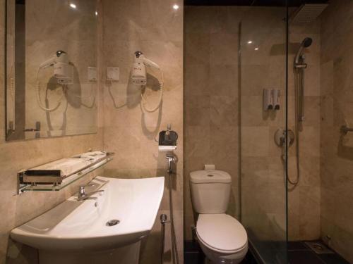 a bathroom with a toilet and a sink and a shower at The Hulo Hotel & Gallery in Kuala Lumpur