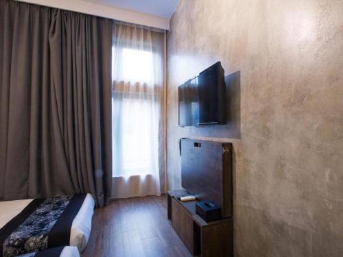a hotel room with a bed and a flat screen tv at The Hulo Hotel & Gallery in Kuala Lumpur