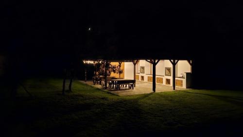 a picnic table in front of a building at night at Osada Mech i Fale in Tarnobrzeg