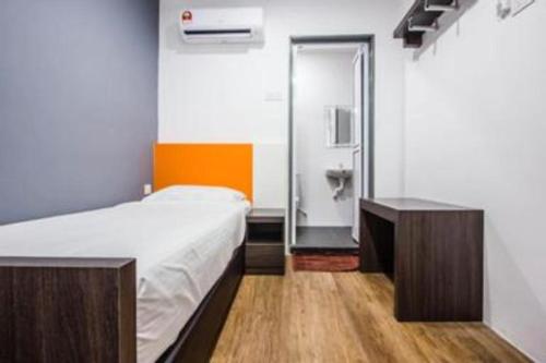 a small room with a bed and a mirror at Big Orange Hotel Jitra in Alor Setar