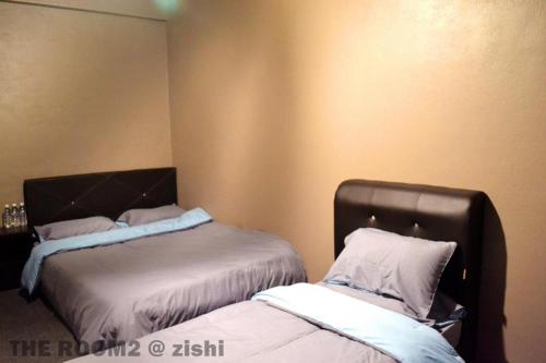a bedroom with two beds and a headboard at THE ROOM2 @ Zishi in Kota Bharu