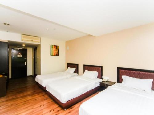 two beds in a hotel room with white sheets at Bay Hotel in Lahad Datu