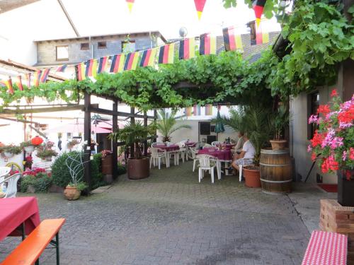 an outdoor patio with tables and chairs and flags at Landgasthaus Zur Kupferkanne in Kobern-Gondorf