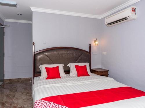 a bedroom with a large bed with two red pillows at OYO 890 Hotel RK Cahaya in Labuan