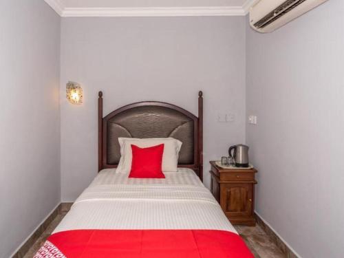 a bedroom with a bed with a red pillow on it at OYO 890 Hotel RK Cahaya in Labuan
