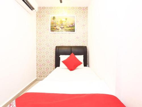 a bedroom with a bed with a red pillow at OYO 718 Mr J Hotel Wakaf Che Yeh 1 in Kota Bharu