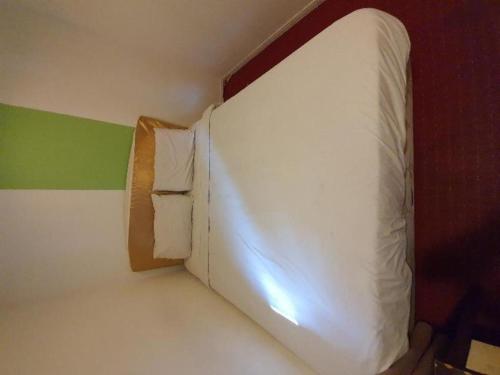 a room with a white bed with a pillow at OYO 1167 Rest and Go Hotel Klang in Klang