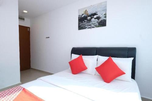 a bed with red and white pillows in a room at OYO 718 Mr J Hotel Wakaf Che Yeh 1 in Kota Bharu