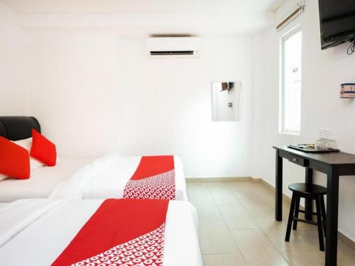 a white room with a bed and a desk at OYO 718 Mr J Hotel Wakaf Che Yeh 1 in Kota Bharu