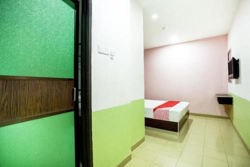 a room with a room with a bed and a door at OYO 89539 Hotel Siswa in Kampar
