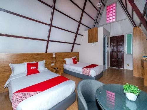 a bedroom with two beds and a table in a room at Dreamland Beach Holiday in Kudat