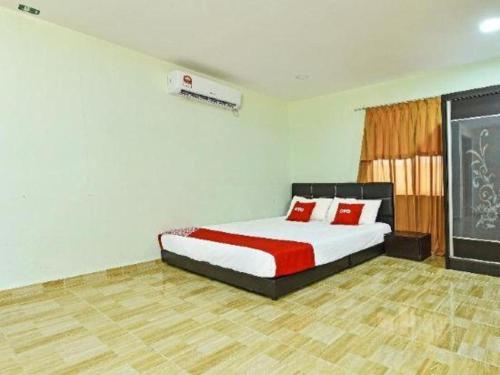 a bedroom with a bed with red pillows on it at OYO 90315 Chalet Pantai Rantau Panjang in Kuala Rompin