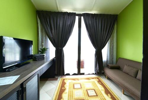 a living room with a couch and a flat screen tv at OYO 90818 Cemara Puri Resort & Spa in Kampong Pantai Batu Hitam