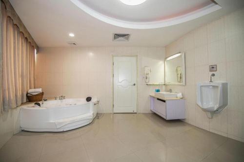 a large bathroom with a tub and a sink at Shunde Emperor Hotel in Shunde