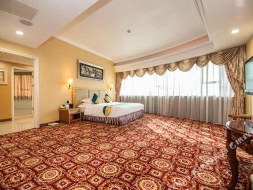 a hotel room with a bed and a large window at Shunde Emperor Hotel in Shunde