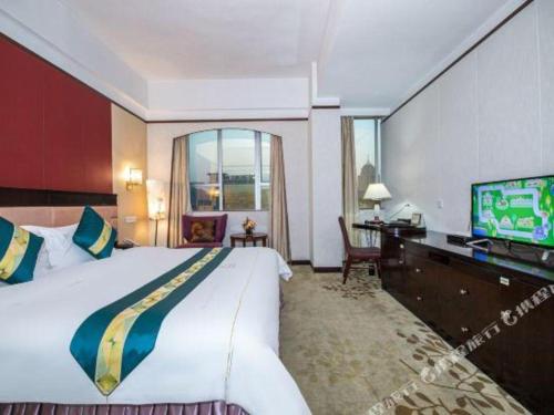 a hotel room with a large bed and a television at Shunde Emperor Hotel in Shunde