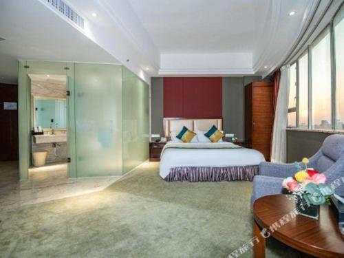 a bedroom with a king sized bed and a living room at Shunde Emperor Hotel in Shunde