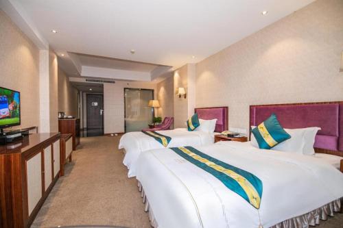 a hotel room with two large beds and a flat screen tv at Shunde Emperor Hotel in Shunde