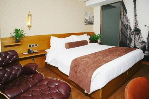 a hotel room with a large bed and a chair at James Joyce Coffetel Xian Big Goose Pagoda Tang Paradise Branch in Xi'an