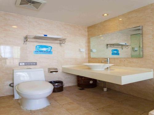 a bathroom with a toilet and a sink at 7 Days Premium Zhuhai Gongbei Light Railway Branch in Zhuhai