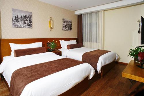 a hotel room with two beds and a television at James Joyce Coffetel Xian Big Goose Pagoda Tang Paradise Branch in Xi'an