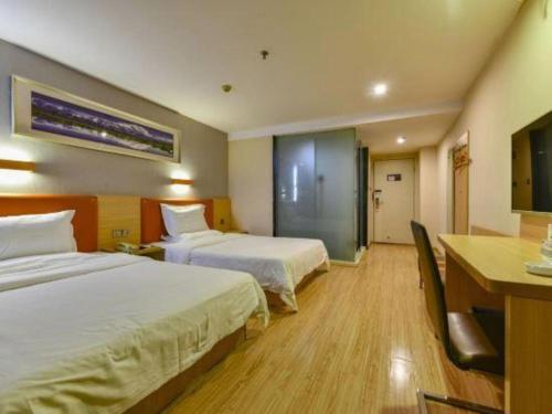 a hotel room with two beds and a desk at 7 Days Premium Zhuhai Gongbei Light Railway Branch in Zhuhai