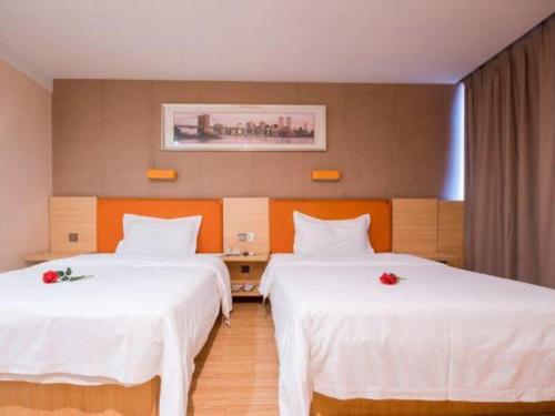 a hotel room with two beds with white sheets at 7 Days Premium Zhuhai Gongbei Light Railway Branch in Zhuhai