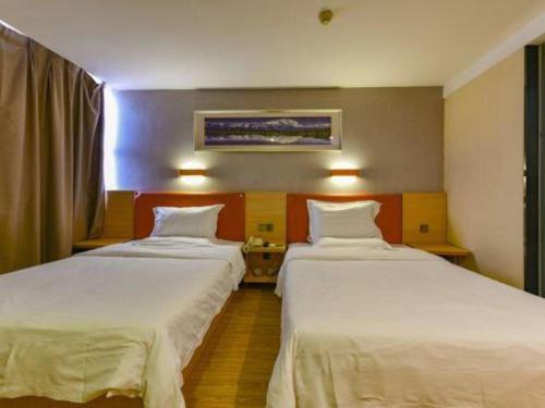 two beds in a hotel room with two beds sidx sidx at 7 Days Premium Zhuhai Gongbei Light Railway Branch in Zhuhai