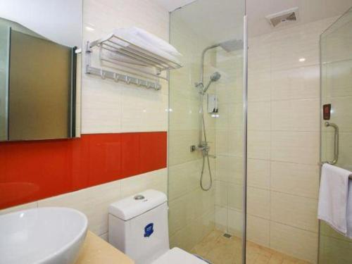 a bathroom with a toilet and a glass shower at 7 Days Premium Zhuhai Gongbei Light Railway Branch in Zhuhai