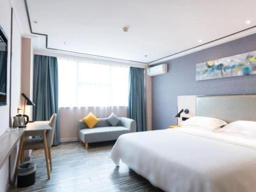 a hotel room with a bed and a couch at 7 Days Premium Zhuhai Gongbei Light Railway Branch in Zhuhai