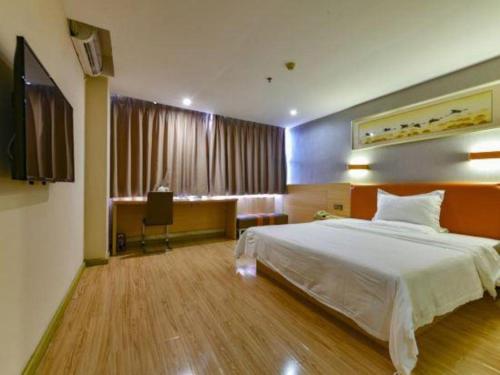a bedroom with a bed and a desk with a chair at 7 Days Premium Zhuhai Gongbei Light Railway Branch in Zhuhai