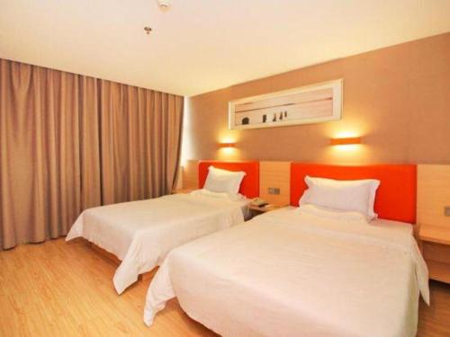 a hotel room with two beds and a window at 7 Days Premium Zhuhai Gongbei Light Railway Branch in Zhuhai
