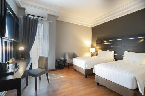 a hotel room with two beds and a desk at Madina Inn Hotel in Sentool