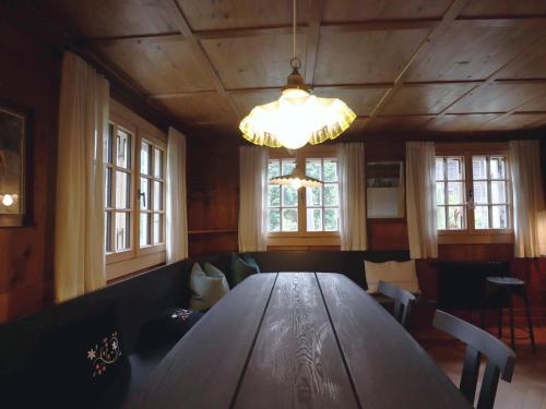 a large wooden table in a room with windows at Chalet in Montafon with Private Sauna & Views in Vandans