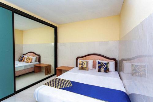a bedroom with two beds and a window at SPOT ON 2815 Hotel Damai in Cilacap