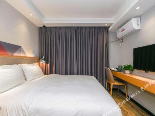a hotel room with a large bed and a desk at Borrman Hotel Zhuhai Gongbei Port Fuhuali Light Rail in Zhuhai