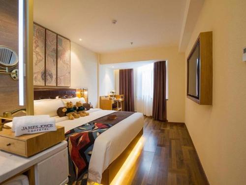 a hotel room with a large bed and a bathroom at James Joyce Coffetel· Hefei Anhui Agricultural University in Hefei