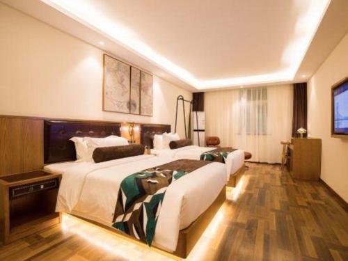 a hotel room with two beds and a television at James Joyce Coffetel· Hefei Anhui Agricultural University in Hefei