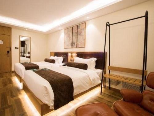 a hotel room with two beds and a couch at James Joyce Coffetel· Hefei Anhui Agricultural University in Hefei