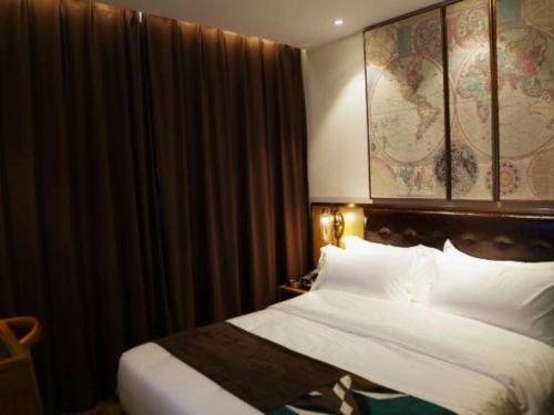 a hotel room with a bed with white sheets at James Joyce Coffetel· Hefei Anhui Agricultural University in Hefei