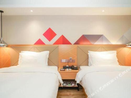 two beds sitting next to each other in a room at Borrman Hotel Zhuhai Gongbei Port Fuhuali Light Rail in Zhuhai