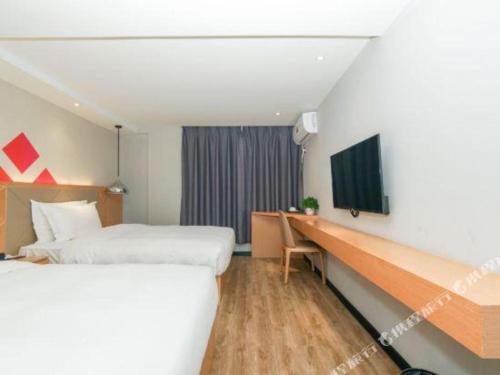 a hotel room with two beds and a desk at Borrman Hotel Zhuhai Gongbei Port Fuhuali Light Rail in Zhuhai