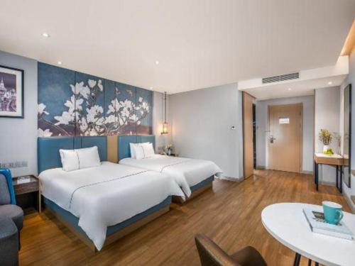 a hotel room with a large bed and a table at Magnotel Hotel Dongxing Guomen Port in Fangcheng
