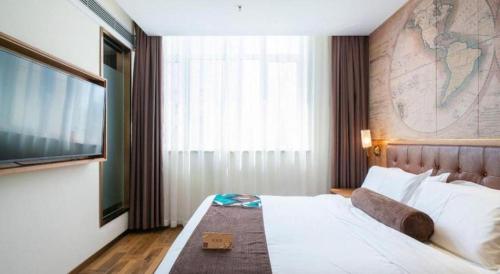 a hotel room with a large bed with a map on the wall at James Joyce Coffetel Shenyang North Railway Station Qishan Road Metro Station in Shenyang
