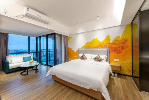a bedroom with a large bed and a couch at Qingyuan Zhongkai Huafu Holiday Hotel in Qingyuan