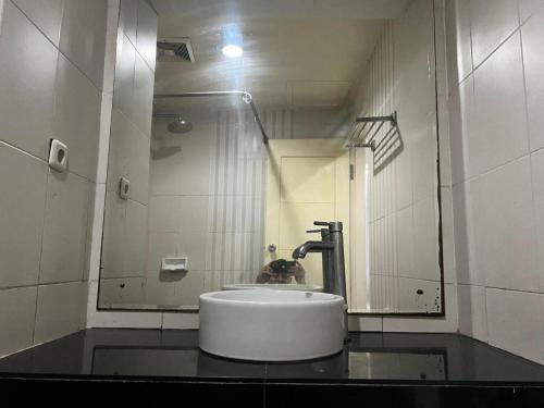 a bathroom with a sink and a mirror at Hotel O Tri Homestay in Palangkaraya