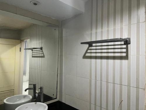 a bathroom with two sinks and a mirror at Hotel O Tri Homestay in Palangkaraya
