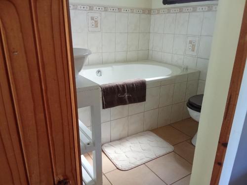 a bathroom with a tub and a toilet at The Retreat Country Lodge in Romelcoh