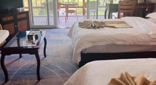 a hotel room with two beds and a table at Kunming Dianchi Garden Hotel & Spa in Kunming